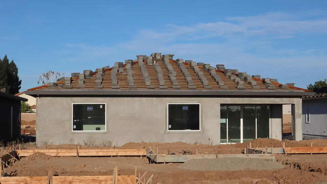 House re-roof in progress with new tiles loaded on battens