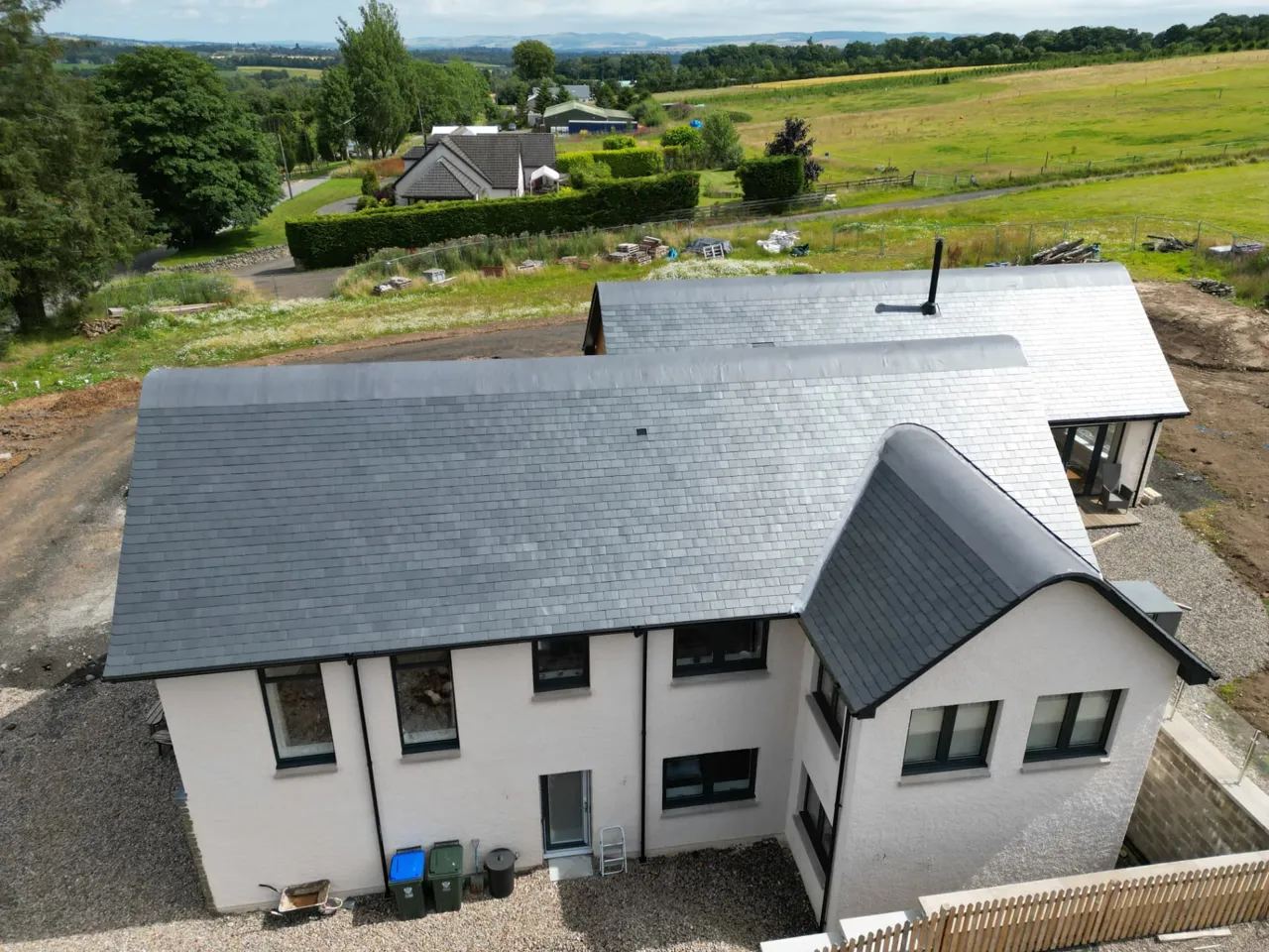 Long run of new slate roofing on a two-storey house, seen from above