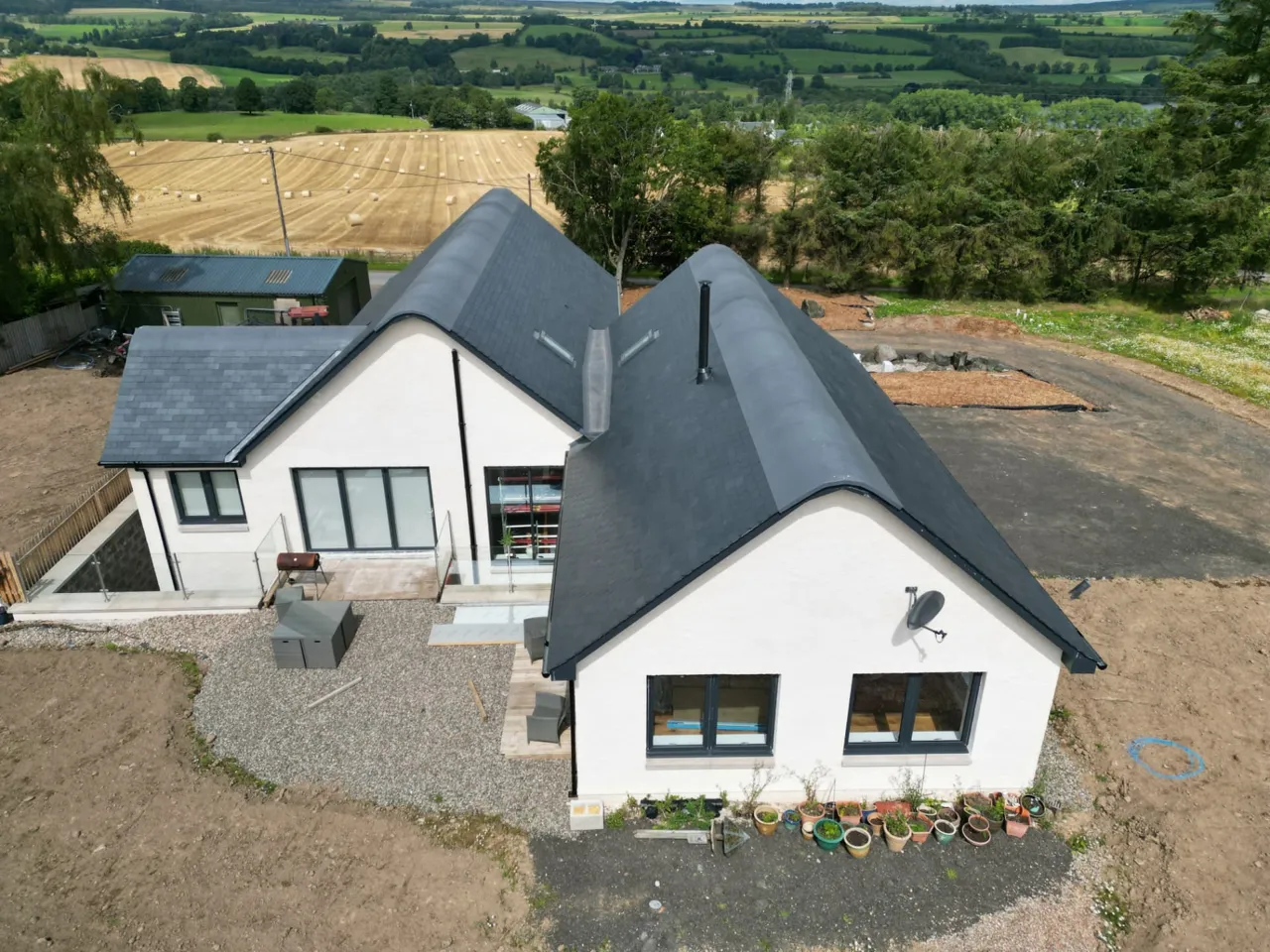 New slate roof on a Perthshire house with rolling countryside behind